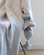 PLAID À POMPONS GRIS