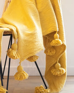 PLAID À POMPONS JAUNE OCRE